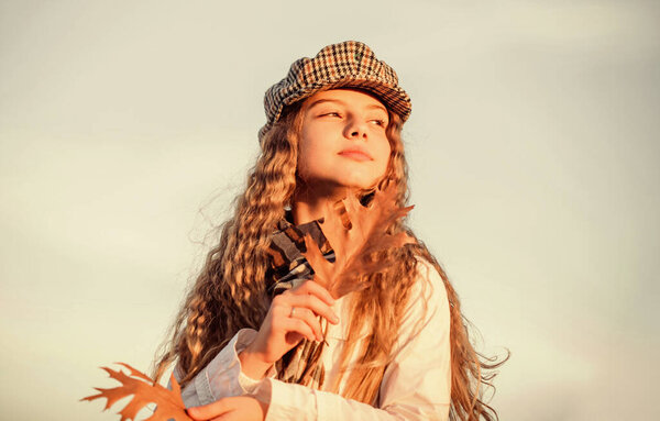 вдохновение. Осенние тенденции. Детская мода. ясная погода. Счастливого детства. Концепция парикмахерской. Маленькая девочка с вьющимися волосами. ребенок держит осенний лист. стильная маленькая девочка в осенней бере