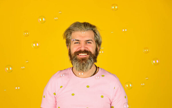 Happiness and joy. Good mood. Play with bubbles. Forever young guy. Positive. Carefree man soap bubbles. Summer vacation. Infantility concept. Happy playful bearded hipster and soap bubbles