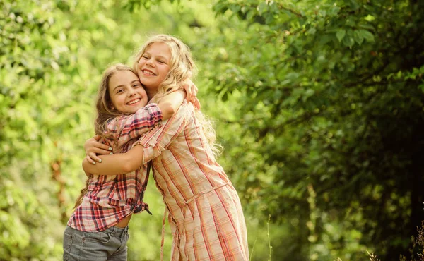 Filles enfants meilleurs amis câlin. Amour et soutien de la fraternité. Bonne enfance. Un concept de câlin et d'amour. Enfants heureux ensemble fond de la nature. Une vraie amitié. Les filles souriant heureux visages étreindre l'autre — Photo