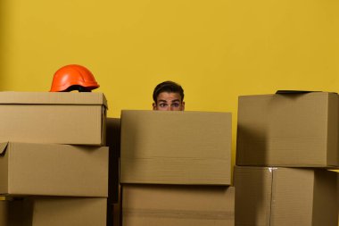 Saçları dağınık adam kutuların arkasına saklanıyor, boşluğu kopyala.