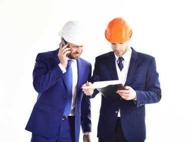 İnşaat, iş, şirket, finans kavramı. Planları ve akıllı telefonu olan girişimci ve mimar.