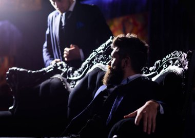 Lüks takım elbiseli suçlu patron klasik koltukta oturur..