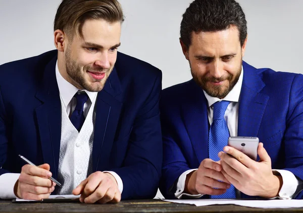 Ortaklık, teknoloji, iş projesi konsepti. İş adamlarının elinde akıllı telefon, kalem ve defter var. — Stok fotoğraf