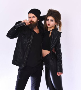 Kız ve sakallı adam siyah deri ceketli ve şapkalı.