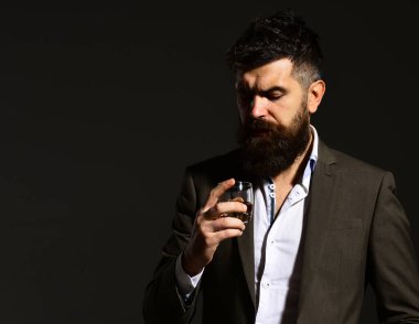 Ciddi yüzlü bir adam bir bardak alkole bakıyor.