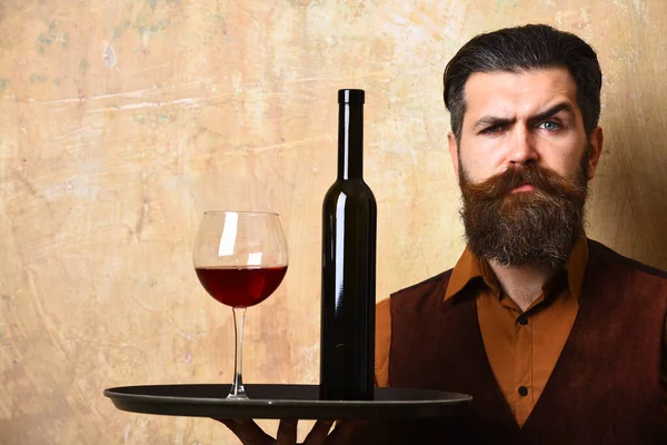 수염을 기르고 수염을 기르고 와인을 비게 벽에 걸고 있는 남자 — 스톡 사진