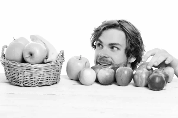 Muž krade jablka z dřevěného stolu u ovocného koše — Stock fotografie