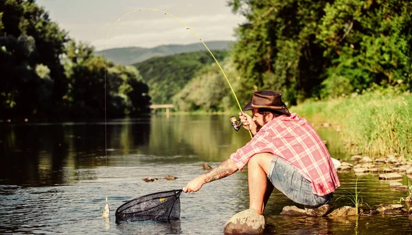 Hobby per l'anima. Uniti alla natura. Pescatore tecnica di pesca utilizzare canna. Un uomo che cattura pesci. Un tizio pesca a mosca. Pesca a mosca di successo. L'uomo sul lungofiume godere di un paesaggio idilliaco e tranquillo durante la pesca — Foto Stock