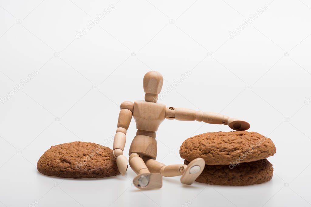 Cookies in stack and wooden toy on white background.