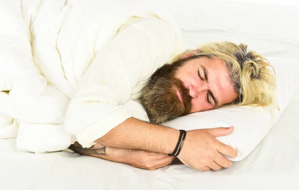 Γενειοφόρος ώριμος άντρας ξαπλωμένος στο κρεβάτι στο σπίτι. Ξέγνοιαστος τύπος που απολαμβάνει μια νέα μέρα. Καλημέρα ρουτίνα. Καυκάσιος γενειοφόρος με λευκή ρόμπα. Χαλαρώστε σε ένα δωμάτιο ξενοδοχείου με ρόμπα. Περισσότερος καφές — Φωτογραφία Αρχείου