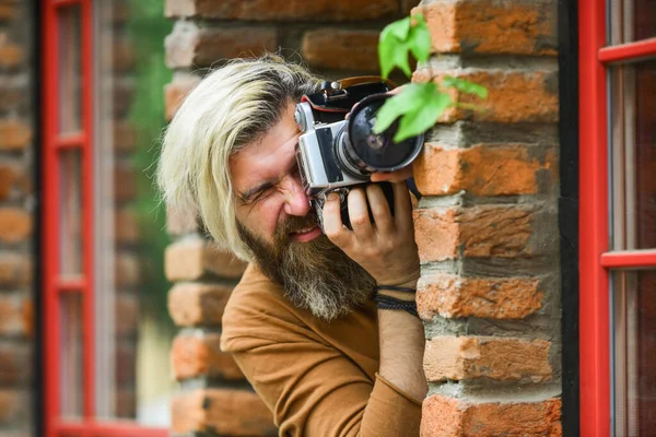 Magánnyomozó. SLR kamera. A szakállas hipszter férfi professzionális kamerát használ. fotós tartsa retro kamera. Az újságíró a karrierem. A riporter fényképez. vintage kamera. rögzíteni ezeket az emlékeket — Stock Fotó