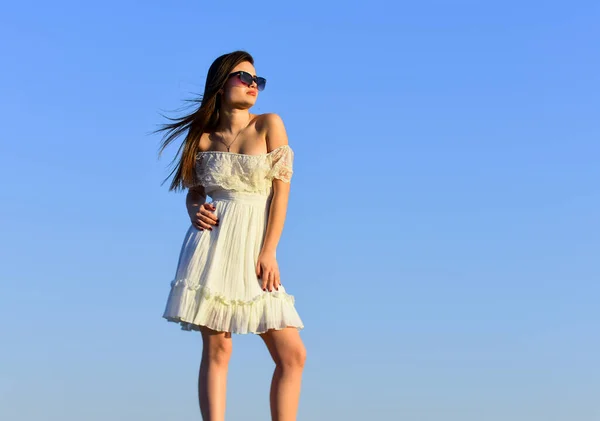 Ha un grande stile. Giovane donna felice posa sopra il cielo blu. bella giovane bella donna con gli occhiali da sole. Vestito estivo. Ritratto della bella ragazza. spiaggia stile moda. Stile di vita all'aperto estivo — Foto Stock