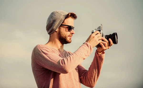 Configuración manual. Concepto de fotoperiodista. Blogger de viajes. Fotógrafo profesional. Guapo fotógrafo chico cámara retro. Guy fotógrafo al aire libre cielo fondo. Hipster reportero tomando fotos — Foto de Stock