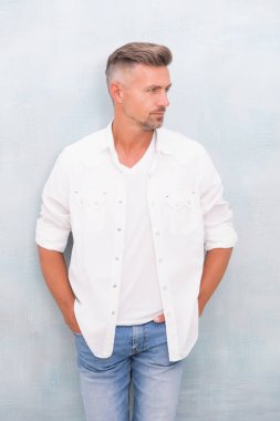 Yakışıklı olgun adam kar beyazı gömlek giyer, yaz kıyafetleri koleksiyonu yapar.