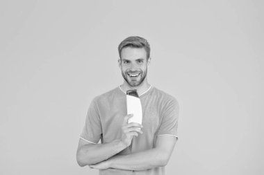 Yakışıklı adam şampuan şişesini tut. Saç bakımı. Sağlık ve sağlık hizmetleri. Erkek kozmetikleri. Profesyonel berber. Banyo ya da duş için vücut bakım ürünleri. Sakallı adam jel tüpü tut. Berber Dükkanı Bakımı