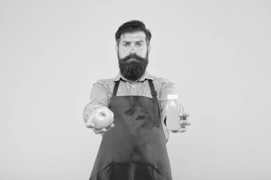Taze meyve suyu. Meyve suyu sıkıyorum. Taze vitamin dağıtıyorum. Hipster içeceği. Erkek sakallı şef organik domates ve şişe sarısı arka plana sahiptir. Vejetaryen beslenmesi. Meyve suyu.