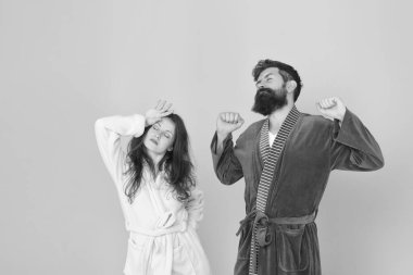 Karantinada hayatta kalan tavsiye ilişkileri. Bütün gün pijama. Uykulu insanlar mavi arka plan. Bornozlu bir çift. Sabahları uykulu ve zayıf. Sabah rutini. Birkaç uykulu yüz ev kıyafetleri