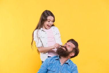 Babam hippi. Küçük kız hippi sakalı çekiyor. Mutlu aile sarı arka planı. Hippi berber dükkanı. Berber dükkanı. Kuaför salonu. Kıllı sakal harika.