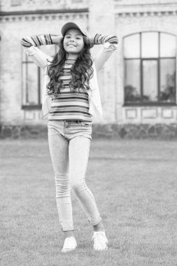 Sokaktaki güzel esmer çocuk. Bahar modası ve güzellik. Mutlu çocuklar günü. Şapkalı şık bir çocuk. Sıcak ve dostça bir gülümseme. Sağlıklı yaşam tarzı kavramı. Şirin küçük kızın kıvırcık saçları var.