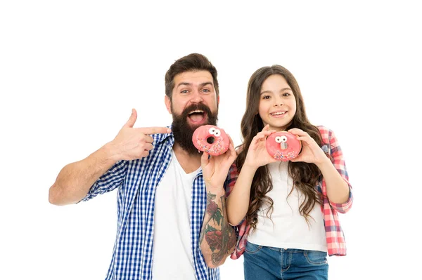 Süßigkeiten und Leckereien Konzept. Tochter und Vater essen süße Donuts. Glück und Freude. Hungriges Kind. Bäckerei. Vatertag. Süßer Zahn. Kind und Papa halten glasierte Donuts in der Hand. Fröhliche Familie — Stockfoto