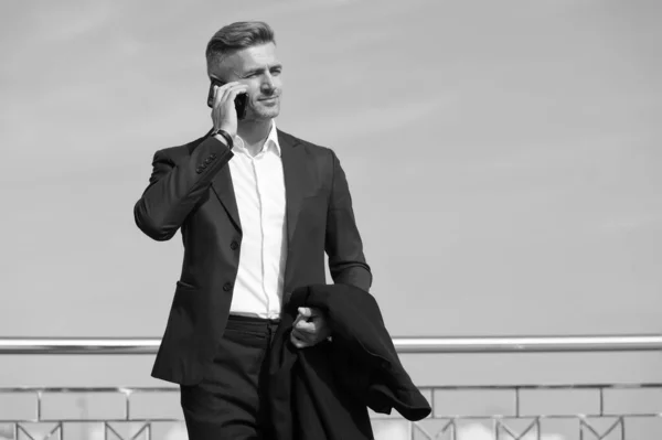 Make decisions on the go. Business concept. Business life. Man classic style blue sky background. Mobile communication. Successful and motivated business man. Businessman well groomed hairstyle