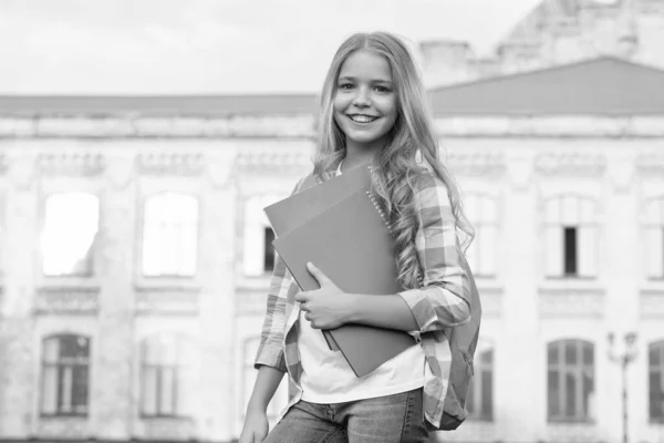 School club. Modern education. Private schooling. Teen with backpack. Stylish smiling schoolgirl. Girl little fashionable schoolgirl carry backpack school building background. Schoolgirl daily life