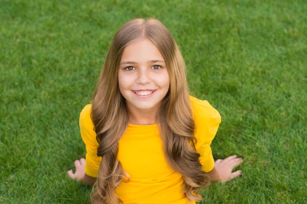 Glücklich lächelndes kleines Mädchen entspannendes grünes Gras, unbeschwertes Kindheitskonzept — Stockfoto