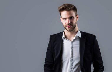 patron erkek. Gri arka planda seksi CEO. Modern ofis hayatı. Karizmatik iş sahibi. Şık bir emlakçı. Yakışıklı adam resmi takım elbise giyer. Gömlek ve ceket giyen kendine güvenen bir iş adamı. Boşluğu kopyala