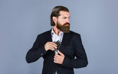 Başka tarafa bakıyor. İçki içen acımasız bir iş adamı. Elinde içki şişesi olan adam. Adam rahatlarken demir mataradan sert alkol içiyor. Viski için kalça matarası. Klasik erkek hediyelik eşya dükkanı.