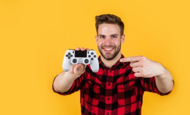 Gelecek şu andır. Adam konsolda oynuyor. Bu benim hobim. Oyuncu bozuntusu. Parti eğlencesi zamanı. Yakışıklı adam oyun konsoluyla oynuyor. Modern teknoloji ve mühendislik. Video oyun konsolu