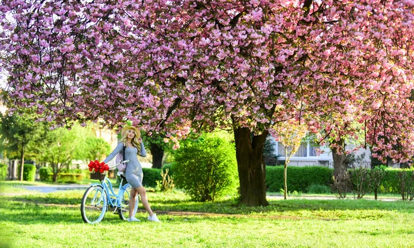 Eko styl życia. Transport ekologiczny. Wycieczka do ogrodu. Sportowa kobieta jeździ na rowerze retro. Podróż rowerem. Wiosenne wakacje. Jazda na rowerze. Dziewczyna i sakura kwitną. Wycieczki rowerowe. Razem z naturą — Zdjęcie stockowe