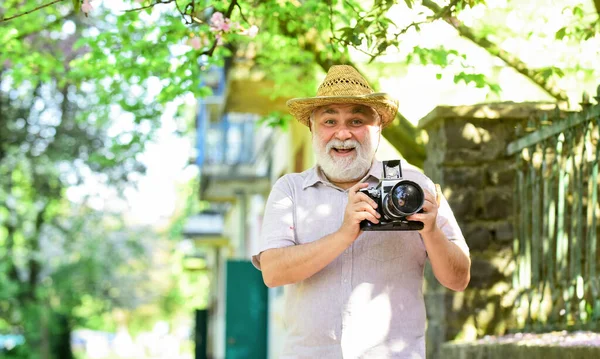 Desfrutando de tempo livre. Viagens e turismo. Capturar a beleza. Homem sênior segure câmera. Viagem de aposentadoria. Férias. Foto de viagem. Fotógrafo no jardim florescente. Caminhando sua rua favorita — Fotografia de Stock