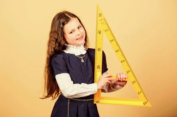 Flicka med stor härskare. Skolelever studerar geometri. Dimensionering och mätning. Kid skoluniformen håller i linjalen. Skolutbildningskoncept. Lär dig matematik. Teoremer och axiom. Smart och smart koncept — Stockfoto