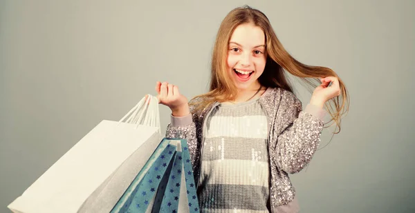 Dopo aver fatto shopping. offerta speciale. Risparmio acquisto vacanze. Saldi e sconti. Alla moda infantile. commessa con pacco. Ragazzina con borse della spesa. Un bambino felice. Bambina con regali — Foto Stock