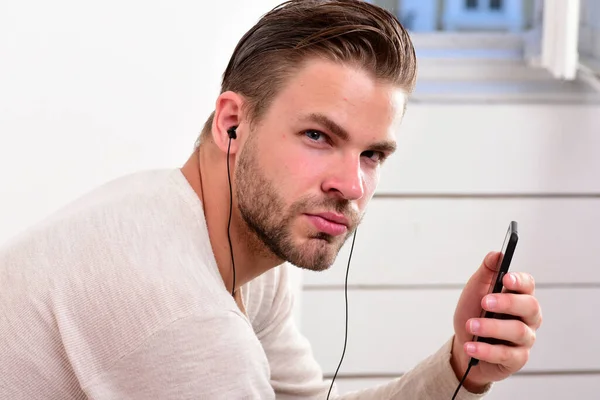 Macho with headphones listens to music. Entertainment and musical lifestyle — Stock Photo, Image