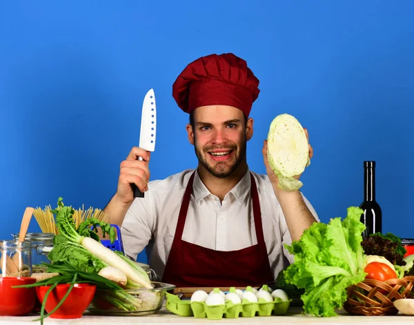 Человек в шапке и фартуке готов резать капусту. — стоковое фото