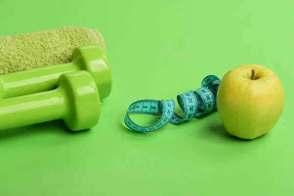 Haltères en couleur verte, ruban à mesurer, fruits et serviette — Photo