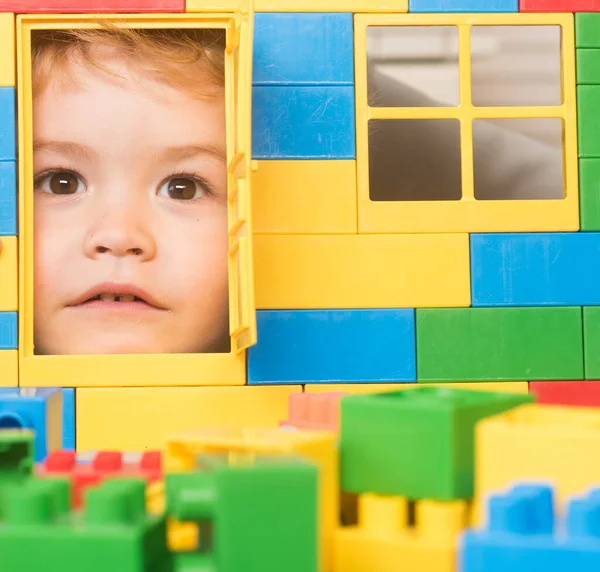 Kid looking through door of toy house made of blocks. — Stock Photo, Image