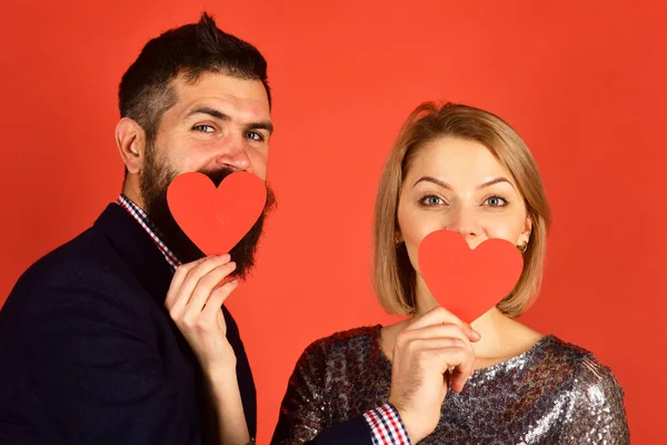 Par i kärlek håller hjärtan på röd bakgrund. — Stockfoto