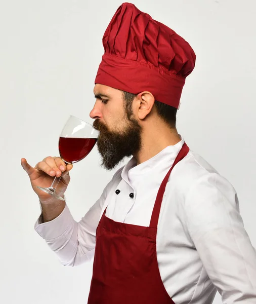 Кухар з серйозним обличчям в бордовій формі п'є алкоголь . — стокове фото