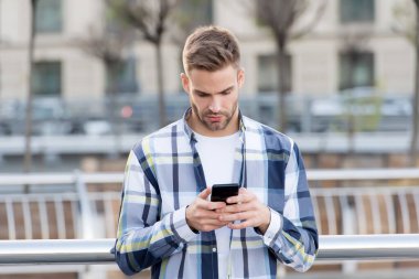 Dünyadaki herhangi bir cep telefonuna anında SMS gönderiliyor. Yakışıklı adam akıllı telefondan SMS okuyor. SMS mesajı. Mobil iletişim. Yeni teknoloji. Modern hayat. 3G mi? 4G mi? Kısa mesaj gönderiliyor