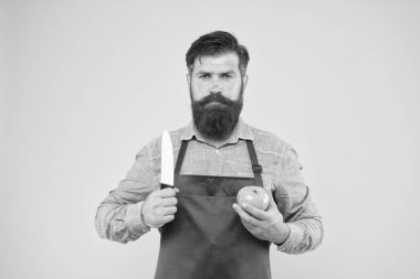 Acımasız aşçı domates kesti. Uzun sakallı, önlüklü bir adam. Yakışıklı, kendine güvenen bir adam sebze yemeği pişiriyor. Sağlıklı beslenme ve beslenme. Vitamin avlamak. Sakallı şef kırmızı önlük giyiyor.