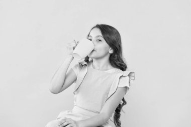 Benim tarzım değil. Yudum alıyorum. Yeterince su iç. Kız çocuğu kupayı sarı arka planda tutar. Güzel çocuk tutuşu kupası. Çay suyu kakaosu içiyorum. İçkiyle rahatlıyor. Çocuk içeceği. Sağlıklı alışkanlıklar