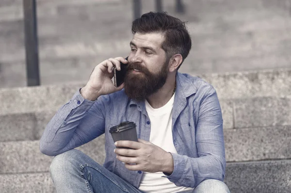 Glad to hear. Hi dear. Modern urban life. Bearded man phone conversation. Mobile conversation. Personal communication. Calling friend. Pleasant conversation. Real connect. Drink coffee while talking