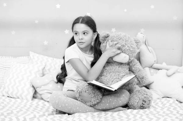 Ev ödevi. Yatak odasındaki sevimli edebiyat okuyucusu. Küçük çocuk oyuncak ayıya kitap okuyor. Çocuk edebiyatı. İngilizce ve edebiyat okuyorum. Kitap ve edebiyat tanıtımı. Ev kitaplığı — Stok fotoğraf
