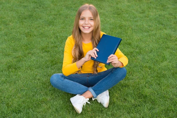 Mädchen lesen Buch im Freien grünen Rasen Hintergrund, Bücher Shop-Konzept — Stockfoto