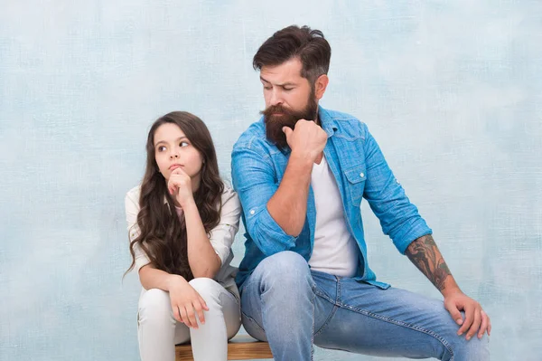 Be what you want to be and wear what you like. Bearded man look at small child. Father and daughter sit on stool. Fashion wear. Casual style. Fashion trends. Trendy style. Hair salon. Barbershop