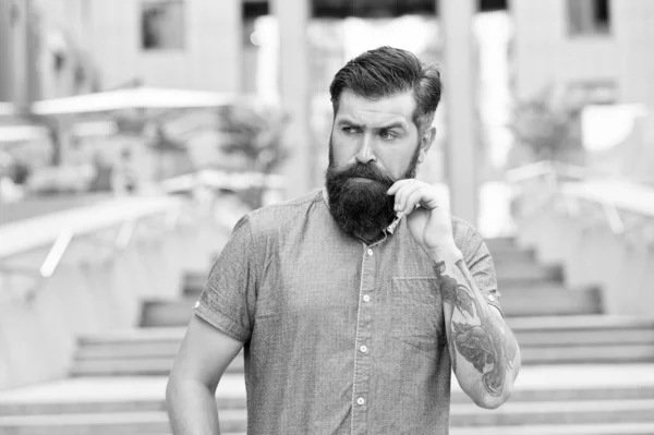 Guy with beard and mustache. Barber salon. Street style. Walking down the street. Mature hipster with beard on stairs. Bearded man. Confident brutal man walk street. Male barber care. Male fashion