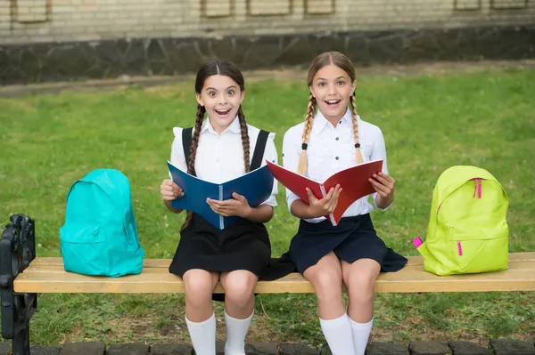 Aprendió algo interesante. estudiantes adolescentes sorprendidos sosteniendo copybook. educación primaria. colegialas aprendiendo juntos. diviértete mientras estudias. Chicas felices en uniforme escolar — Foto de Stock