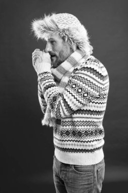 Isınıyorum. Kış modası. Örülmüş aksesuarlar. Soğuk kış koşulları. Şapka ve eşarp kırmızısı arka plan giyen yakışıklı sakallı adam. Sahte kürk. Erkek giyim konsepti. Moda koleksiyonu. Moda kıyafetleri.